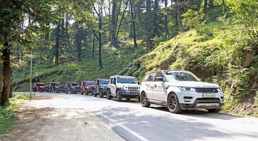 Adventures Overland expedition vehicle driving through a lush green forest